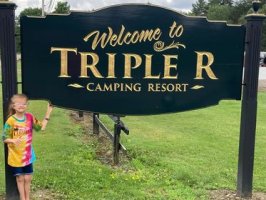 Sara standing in front of the Triple R sign with her Triple R sweatshirt on