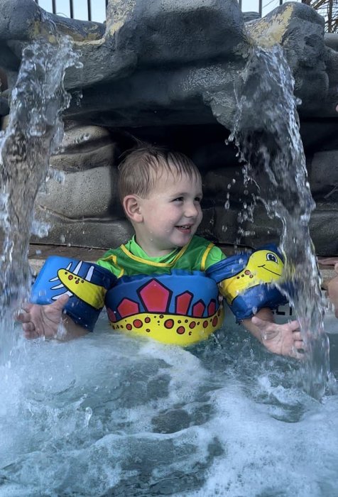 Kids playing under the water fall at Triple R